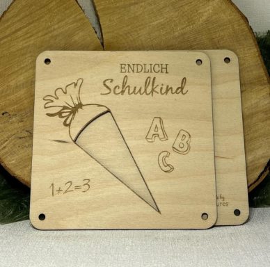 Holzplatte mit dem Text "Endlich Schulkind" und einem Kegeldesign mit ABC und 1-2-3.